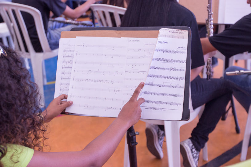 Singing Classes Near Me is hosting a group Voices Lesson and her students are standing behind music stands at the Vocal Studio