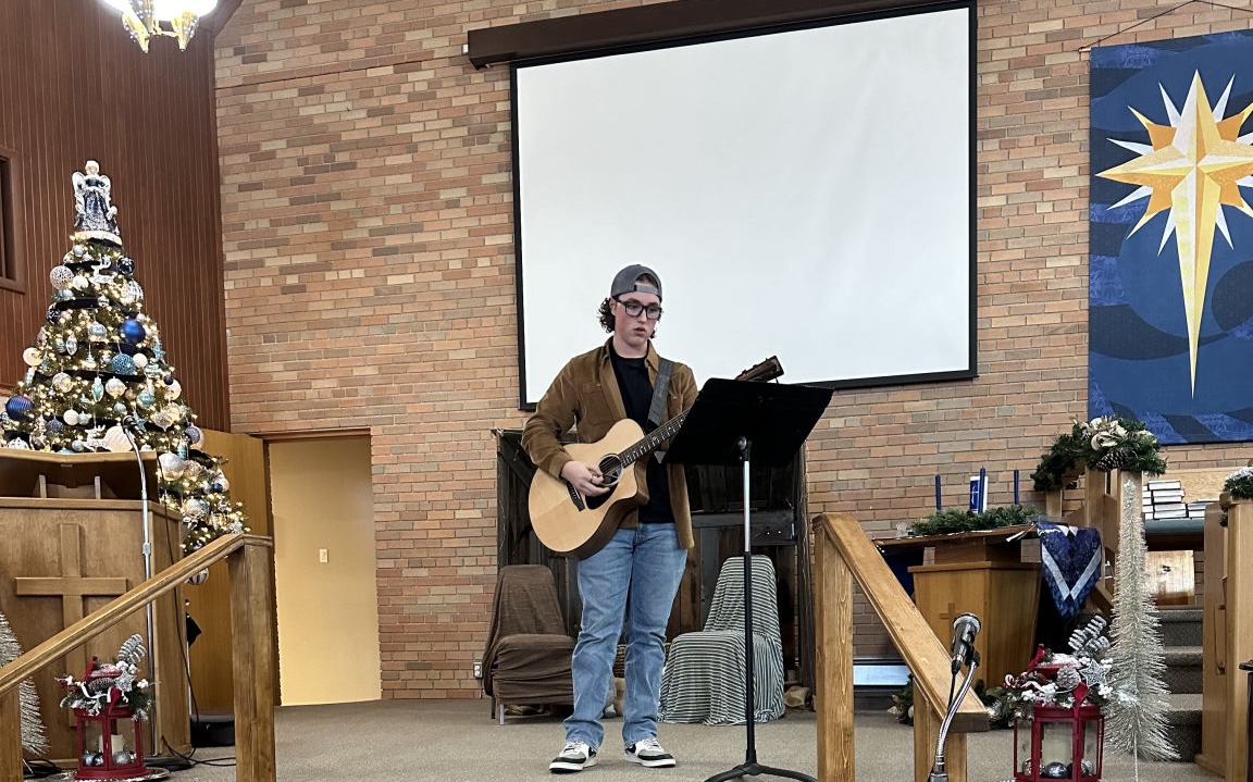 Maria Drost male student Sings plays the guitar demonstrating skills he learned at the Voice Academy that he could use to work as one of Singers For Weddings